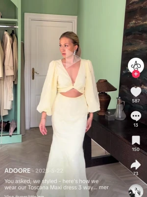 Ljusgul långklänning från Adoore - Trendig ljusgul långklänning från Adoore med v-ringning, ballongärmar och snygg cut-out vid midjan. Klänningen har en figurnära passform och är perfekt för dig som vill sticka ut med en modern och elegant look. Aldrig använd! 