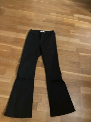 Svarta utsvängda leggings - Säljer ett par svarta leggings med utsvängda ben. De har en hög midja och är i stretchigt material som sitter skönt på kroppen. Perfekta till sneakers eller boots för en trendig look.