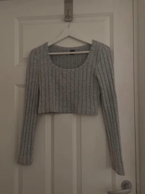 Grå croppad topp - Säljer en grå croppad topp från shein i storlek M. Materialet på tröjan är väldigt mjuk och skön