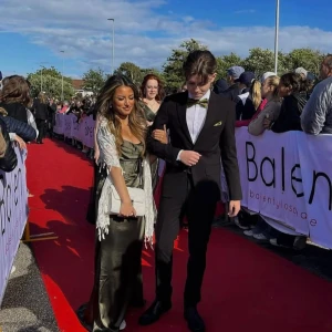 Olivgrön balklänning strl XS - Säljer en elegant olivgrön långklänning med omlott och djup v-ringning. Klänningen har kort ärm och ett glansigt material som ger en lyxig känsla. Perfekt för balen passar till 155-165 . Har även inbyggda padding vid bysten