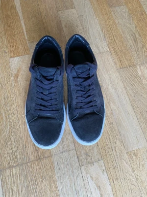 Svarta sneakers från Vagabond - Stilrena svarta sneakers från Vagabond med klassisk låg profil och vita sulor. Skorna har ovandel i mocka och textil, samt matchande svarta skosnören. Perfekta för en clean och enkel look till vardagsoutfiten.