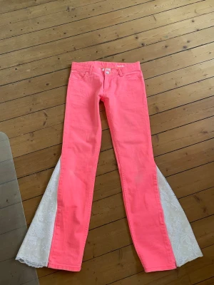 Unika rosa jeans med spets - Säljer dessa unika rosa jeans som är omsydda till bootcut med spets. Midjemått 35 cm och innerbenslängd 77 cm. Jeansen är i väldigt bra skick. Kontakta mig privat vid frågor eller liknande💞💞