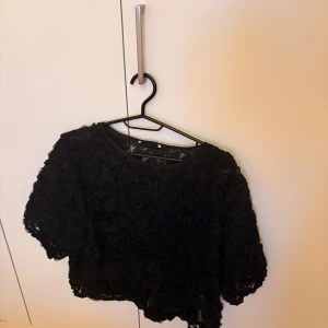 Svart blus - Säljer denna svarta blus med blommigt mäster från New Yorker. Storlek M och inte använt så mycket. 