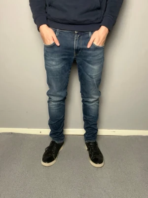 Mörkblå replay anbass jeans - Säljer ett par blå slim fit jeans med snygg tvätt och lätt slitna detaljer. Mycket bra skick. Frågor? Skicka ett meddelande.