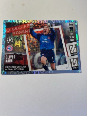 Topps Legendary Moment fotbollskort - Säljer ett glittrigt samlarkort från Topps med motiv av Oliver Kahn från Bayern München. Kortet har texten 'Legendary Moment' och visar statistik från UCL-finalen 00/01. Kortet har holografisk yta och tydliga färger i blått, rött och silver.