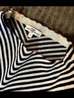 Randig stickad tröja Hampton Republic - Säljer en stickad tröja från Hampton Republic i storlek S. Tröjan har klassiska svarta och vita ränder och en snygg metallbricka med logotypen på nederkanten. Materialet är mjukt och bekvämt, perfekt för att skapa en cool och avslappnad look.                                  Bystmått - ca 51 cm Armlängd - ca 56 cm Längd - ca 57 cm