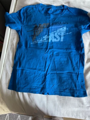 Blå t-shirt från Soi med tryck - Blå t-shirt från Soi med ett stort tryck på bröstet i svart och vitt. Klassisk rund halsringning och korta ärmar. Tillverkad i mjuk bomull som känns skön mot huden. Perfekt för en avslappnad och cool stil.