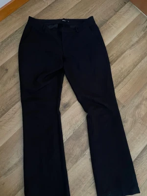 VERA FLARED KOSTYMBYXA - Svarta kostymbyxor från BIKBOK i modellen Vera Flared, använda men i bra skick!