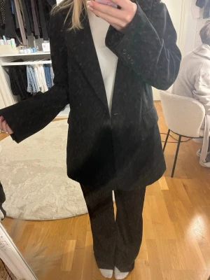 Oversized svart kavaj - Stilren oversized svart kavaj med klassisk krage och tre knappar vid ärmslutet. Kavajen har raka axlar, två fickor framtill och är tillverkad i ett slätt tyg som ger en snygg och modern look. Perfekt för att lyfta vilken outfit som helst. Storleken är xs/s