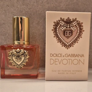 Dolce & Gabbana Devotion EdP 30ml - Lyxig parfym från Dolce & Gabbana, Devotion Eau de Parfum Intense. Flaskan är fyrkantig i glas med guldigt hjärtdetalj och guldfärgat lock. Doften kommer i en elegant beige kartong med gulddetaljer. Volym: 30 ml.