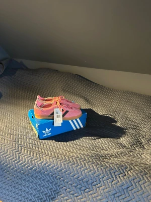 Adidas rosa sneakers med gummisula - Snygga rosa Adidas sneakers med klassiska svarta ränder på sidan och gummisula. Skorna är helt oanvänd, nya, aldrig använda. Hör av er vid frågor!