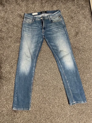 Blå jeans från Replay i modell Rocco - Snygga blå jeans från Replay med klassisk femficksdesign och raka ben. Jeansen har en tvättad look med ljusare partier framtill och bakfickor med diskreta sömmar. Tillverkade i bomull för en bekväm känsla och stilren passform. 