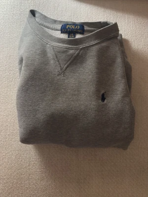 Grå stickad tröja från Polo Ralph Lauren - Skick:9,5/10🍾🔥👍🏻                                                Storlek: cirka: 154-166                                            Säljer för att storleken inte passar.                      I princip helt ny✅🔥