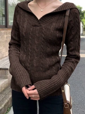 Brun kabelstickad hoodie - Mysig brun kabelstickad tröja med huva och djup v-ringning. Tröjan har långa ärmar och ribbade muddar samt en figurnära passform. Perfekt för dig som gillar en avslappnad men ändå stilren look.