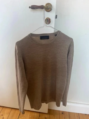 Beige stickad tröja Tailored Originals - Säljer en stilren beige stickad tröja från Tailored Originals. Tröjan har rund halsringning och långa ärmar. Storlek m på tröjan men sitter mer som en s/xs, den sitter ganska tajt runt armarna
