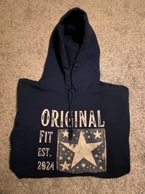 Snygg ”ORIGINAL FIT ” hoodie !  - Snygg mörkblå hoodie ”Original fit” säljes för en cool och avslappnad stil! Supersnygg till vita linnebyxor i sommar 👌