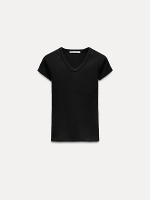 Svart ribbad v-ringad t-shirt från Zara - En stilren svart t-shirt från Zara med v-ringning och korta ärmar. Slimpassform oxh liten i storlek, skulle säga en XXS, inte S. Aldrig använd. 