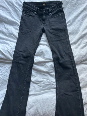 Svarta bootcut jeans från Lee - Snygga svarta bootcut jeans från Lee med klassisk femficksdesign och dragkedjegylf. Jeansen är väldigt lågmidjade! 