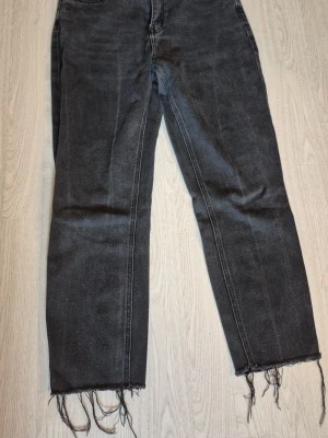 Svarta raka jeans med rå kant storlek w29L30 - Säljer ett par svarta raka jeans med trendig rå kant nertill. Jeansen har klassisk femficksmodell och normal midja. Materialet är denim i bomull och färgen är tvättad svart. Perfekta för en avslappnad och cool stil. Från veromoda. Katt finns I hemmet.