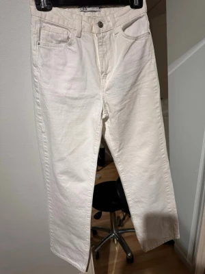 Vita raka jeans från Zara - Snygga vita jeans från Zara med rak passform och klassisk femficksdesign. Jeansen har hög midja och är tillverkade i ett kraftigt bomullstyg. Perfekta för en clean och stilren look. Perfekta nu till sommaren och sitter jättefint på!! 🌸