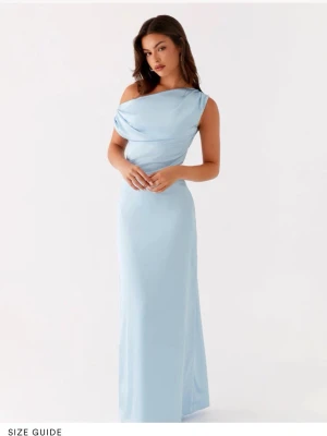 Ljusblå långklänning med oneshoulder - Elegant ljusblå långklänning med oneshoulder-design och draperad överdel. Klänningen har en smickrande, figurnära passform och är tillverkad i ett mjukt, glansigt material som ger en lyxig känsla. Perfekt för speciella tillfällen när du vill sticka ut. Säljer pågrund av att den tyvärr var för stor.