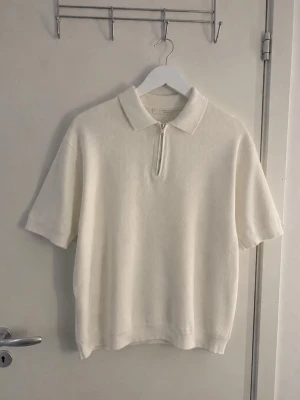 zara vit polotopp med half zip - Vit polotopp i ribbad bomull med kort ärm och halv dragkedja framtill. Klassisk krage och avslappnad passform, perfekt för en clean och stilren look✨Skulle säga att den sitter mer som L!