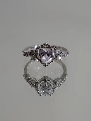 Silverfärgad ring med hjärtformad sten - Silverfärgad ring med rosa kristall hjärta i storlek: 17,7mm (i diameter) eller 55,6mm (i omkrets)