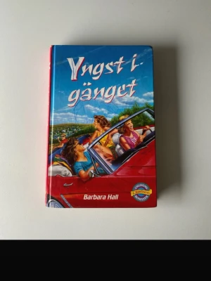 Yngst i gänget av Barbara Hall - Ungdomsroman med hårda pärmar, färgstark framsida med illustration av ungdomar i en röd cabriolet. Boken är skriven av Barbara Hall och ges ut av B. Wahlströms. Perfekt för dig som gillar berättelser om vänskap, identitet och att hitta sin plats i gänget.