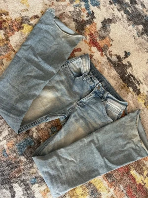 Ljusblå jeans med avklippta ben - Ljusblå jeans i klassisk femficksmodell med avklippta ben och råa kanter. Jeansen har en något tvättad look och normal midja. Perfekta för dig som gillar en edgy och unik stil. Materialet är denim i bomull.