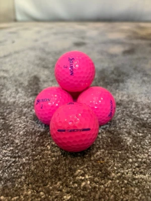 Fyra rosa golfbollar från Srixon - Säljer fyra snygga rosa golfbollar från Srixon. Bollarna har klassisk rund form och är tillverkade i slitstarkt material med text och nummer tryckta i blått. Perfekt för dig som vill sticka ut på golfbanan. Skriv privat för pris