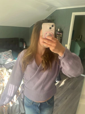 Ljuslila omlottstickad tröja Gina Tricot - Superfin ljuslila stickad omlott-tröja från &Other Stories med knytband i sidan och v-ringning. Tröjan har långa ärmar och ribbstickade muddar vid ärmslut och nederkant. Perfekt för sommarkvällar och en trendig look. Nästan aldrig använd! Pris kan diskuteras💕