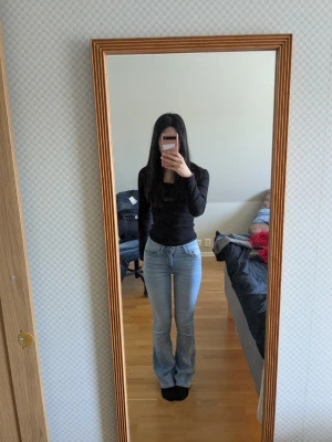 Ljusblå bootcut jeans från ONLY - Säljer ett par ljusblå bootcut jeans från ONLY med klassisk femficksdesign och normal midja. Jeansen har en snygg tvätt och är tillverkade i mjukt denimtyg som sitter bekvämt. Perfekta för dig som gillar en avslappnad men trendig look.