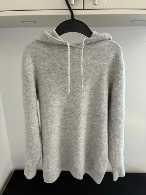 Merinoull hoodie - Säljer en merino ull hoodie grå i fint skick. Varm och skön som passar till mer avslappnande dagar. Rekommenderas till någon som är ca 160-165. Hör av er vid frågor!