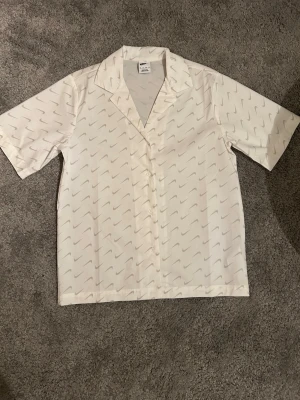 Nike skjorta  - Vit skjorta från Nike. Direkt från Nikes hemsida, den är helt ny och såklart äkta. Storlek xs, pris kan diskuteras 🤍👔(köpare står för frakt)