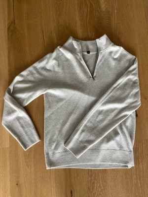 Ljusgrå stickad tröja med halv dragkedja - Half zip från uniqlo i 100% cashmere, ljusgrå skön tröja som knappt är använd. Rensar garderoben och denna chill tröja åker upp för försäljning.