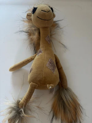 Mjuk giraff från Jellycat - Säljer ett gulligt mjukdjur i form av en giraff från Jellycat. Giraffen är beige med bruna och glittriga rombformade fläckar, har lång hals, lurvig man och svans samt mjuka ben. Perfekt som dekoration eller kramkompis.