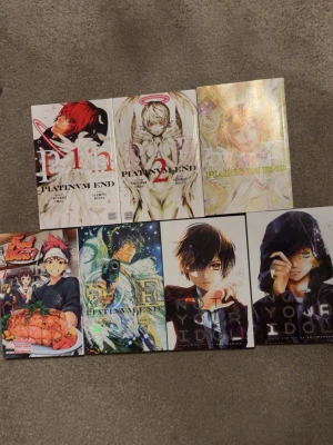 Manga-paket: Platinum End, Food Wars, Not your Idol - Säljer ett paket med manga: flera volymer av Platinum End med färgstarka omslag och glänsande detaljer, en volym av Food Wars med mattema samt två volymer av Not Your Idol. Perfekt för dig som gillar spännande och visuellt snygga serier.