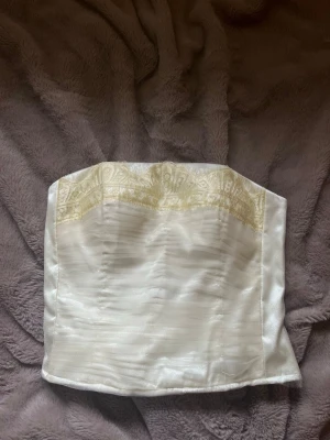 Ljusgul korsett med spetsdetaljer - Elegant ljusgul korsett med vacker ljusgul spets upptill. Från laona i storlek 36