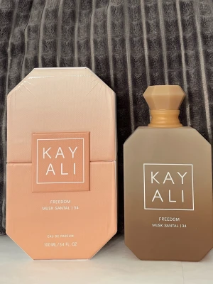 Kayali Freedom Musk Santal 34  - Kayali Freedom Musk Santal 34 eau de parfum 100ml flaska köpt från sephora  öppnad nu i juni 2026  Noter  Pink pepper Soft freesia  Soft Lily  Orange blossom Candied amber Musk santal   Den är endast  test sprayad.  Se bilder. Automizern sprayar försiktigt.  