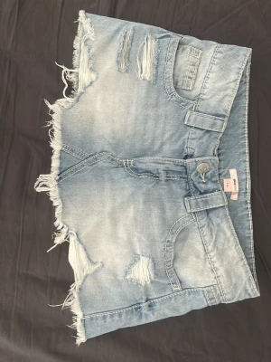 Ljusblå jeanskjol med fransar - Säljer en ljusblå jeanskjol med slitna detaljer och fransig nederkant. Kjolen har klassiska fickor fram och bak, bälteshällor och knappstängning. Perfekt för dig som gillar en avslappnad och trendig stil. Köot på vinted men säljer då den var för stor🩷 