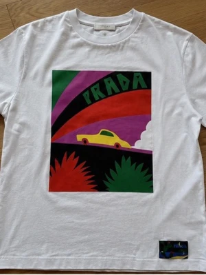 Prada T-shirt - Vit T-shirt från Prada i storlek S. T-shirten kommer i topp skick då den endast är använd 3 gånger. Väldigt efterfrågan T-shirt som är svår att få tag på. Nypriss 3500kr. Hör av er vid intresse och vid önskan om fler bilder!