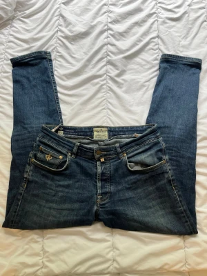 Mörkblå slim fit jeans från Morris - Feta mörkblå slim fit jeans från morris, jeansen har låg midja och smal passform, Materialet är mjukt denim med lätt tvättad look.