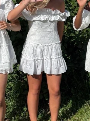 Vit offshoulder klänning med volang - Eftertraktad klänning från Zara. Perfekt för sommarens alla tillfällen. Storlek L men passar bättre som M. Inga tecken på användning. Kom gärna med prisförslag💝