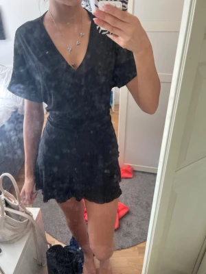kort omlottklänning - gullig svart kort omlottklänning från gina tricot med v ringning och volang, aldrig använd🩷