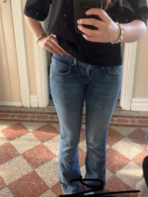 Blå bootcut jeans med låg midja - Säljer ett par ljusblå bootcut jeans med låg midja och klassiska fem fickor från ltb!🫶🏻Jeansen har en lätt tvättad look och sitter tajt över låren för att sedan bli vidare nedtill. Perfekta för en avslappnad och trendig stil.🤍