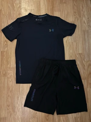 Under Armour Set  - Snyggt svart träningsset från Under Armour med t-shirt och shorts. Storlek M på båda 