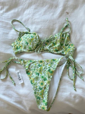 Blommig bikini med snörning - Bikini från bikbok BH:n i storlek S och underdelen XS men tyckte underdelen var lite stor i storleken, använd en gång