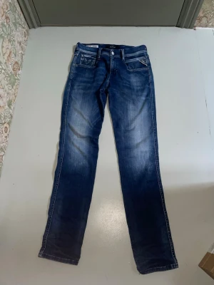 Blå replay jeans - Snygga blå jeans med raka ben och diskreta slitningar på framsidan. Klassisk femficksmodell med kontrastsömmar och normal midja. Jeansen har en cool tvättad look och är perfekta för en avslappnad stil. Materialet är denim i bomull.