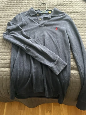 Mörkblå långärmad skjorta Polo Ralph Lauren - Säljer en mörkblå långärmad skjorta från Polo Ralph Lauren i slim fit-modell. Skjortan har klassisk krage, knappar vid halsen och en liten röd broderad logga på bröstet. Tillverkad i mjuk bomull som känns skön mot huden. Använd max 3 gånger kan mötas i sthlm PRIS KAN DISKUTERAS OCH TAR EMOT BYTEN!