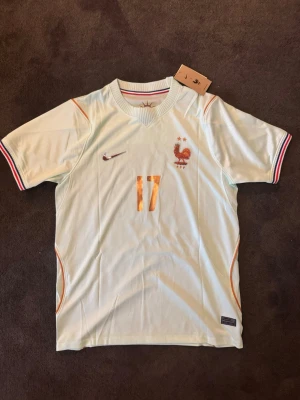 Frankrike VM 26/27 borta Saliba 17 - OBS! Tröjan ser lite konstig ut pga ljuset skriv privat för mer bilder.                   Tröjan är helt ny med tagg kvar och i perfekt skick. Storlek M. Perfekt för dig som är supporter, samlar på fotbollströjor eller vill ha en snygg tröja till träning och vardag. 🔹 Storlek M 🔹 Helt ny med tagg 🔹 Saliba 🔹 Skickas inom 24 timmar Vid intresse eller frågor är det bara att skicka